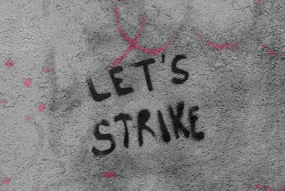 Actors on strike with picket signs, affecting new movie and TV show releases