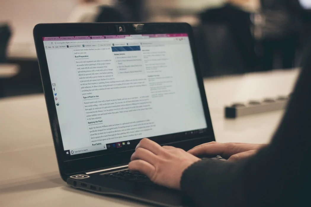 Young woman typing on laptop, showcasing the importance of blogging for content creation