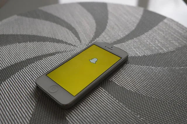 Snapchat ghost logo icon on a smartphone with other social media apps