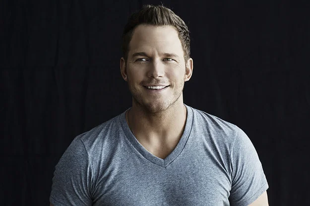 Chris Pratt smiling, posing with a bottle of Michelob Ultra beer