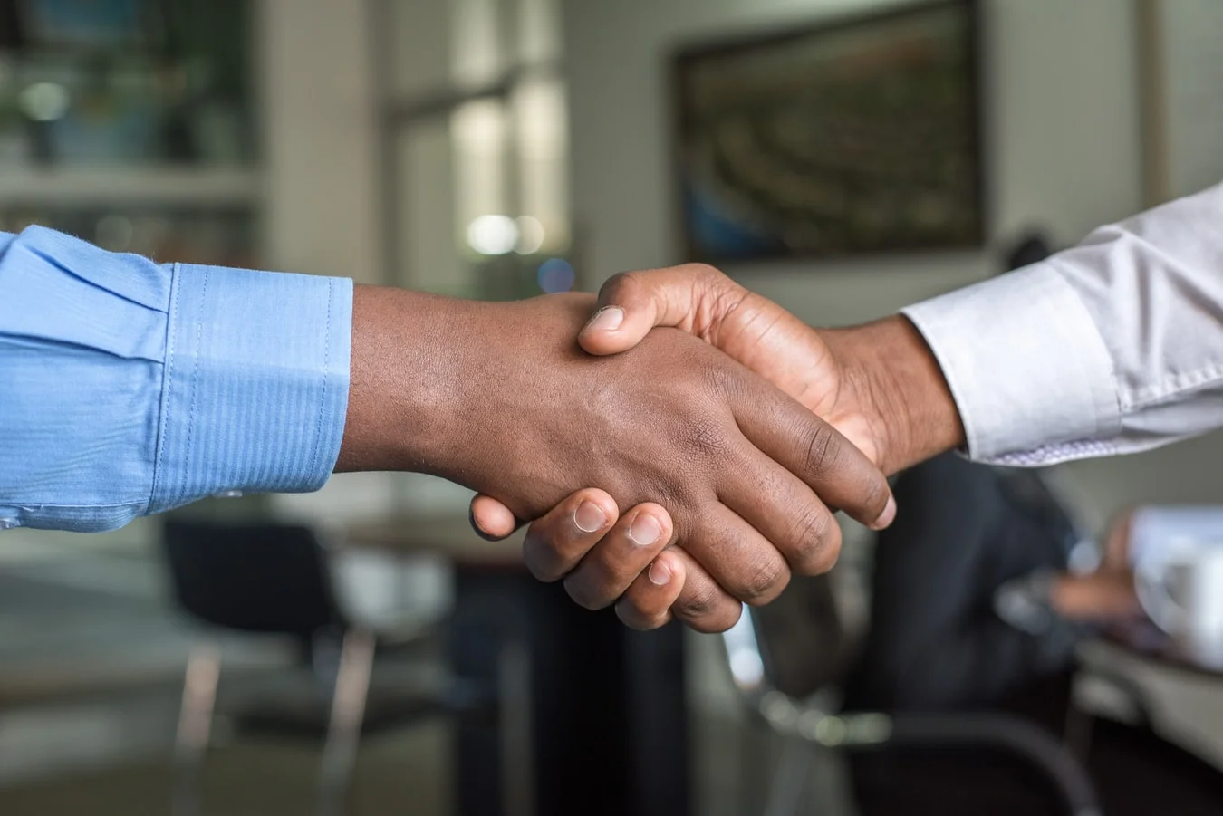 Two diverse business partners shake hands, symbolizing successful collaboration and shared values