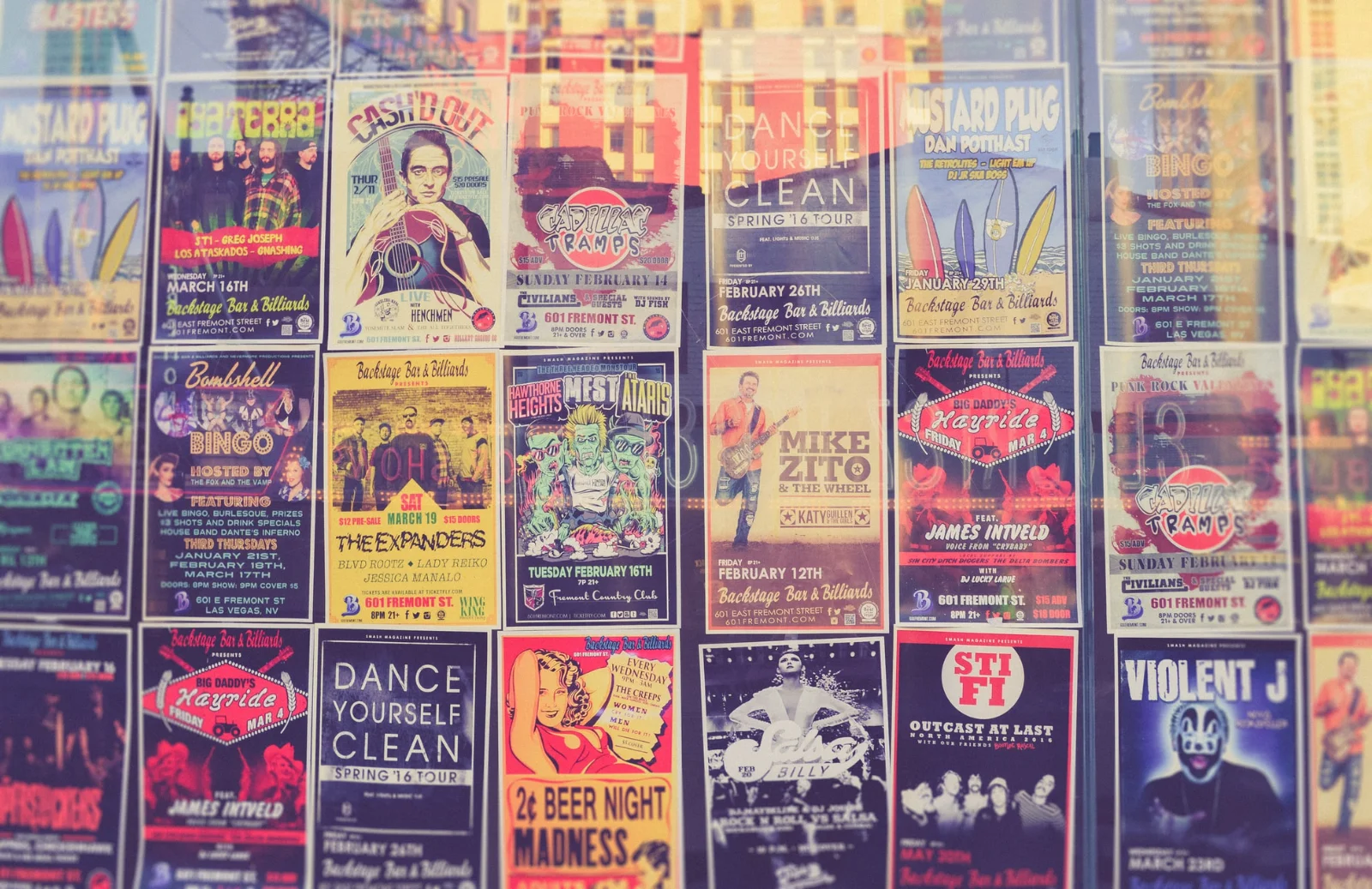A person's hand affixing a colorful flyer to a public bulletin board