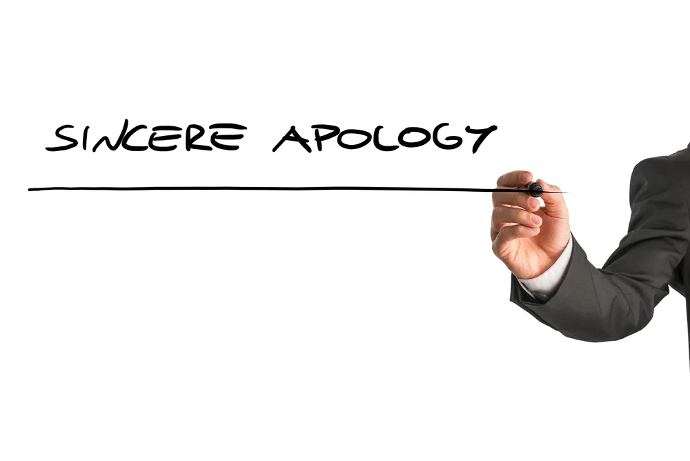 **Alt text: A hand extending a sincere apology as a corporate leader.**
