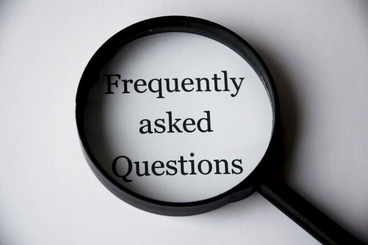 Customer service representative holding magnifying glass over frequently asked questions