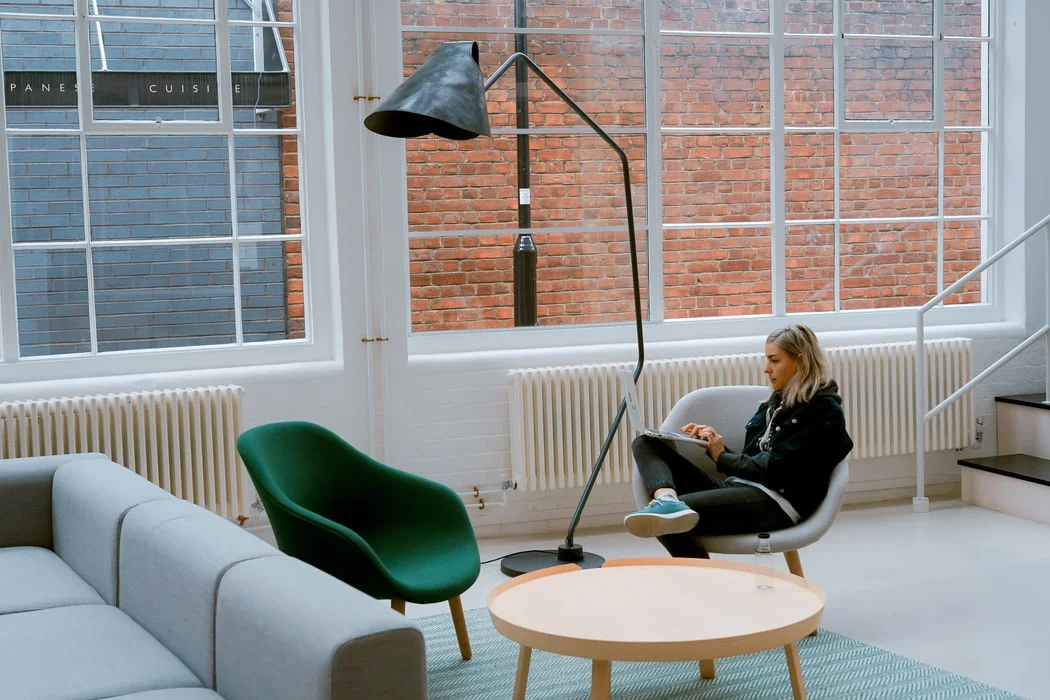 Woman in a suit jacket rehearsing a marketing pitch in front of a mirror