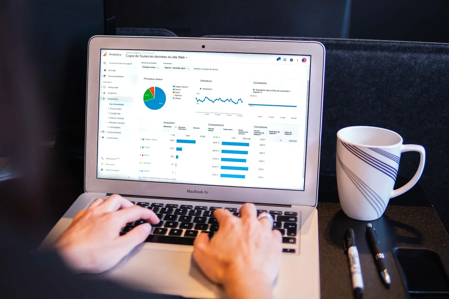 A magnifying glass over a spreadsheet of business data and graphs