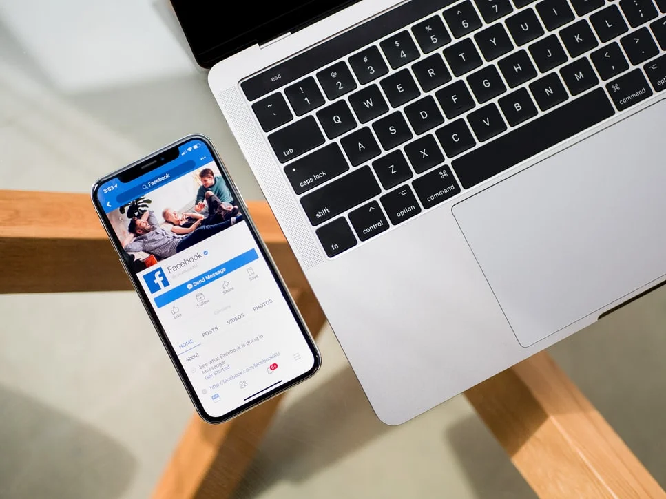 Woman using laptop with Facebook open, marketing on social media platform digitally