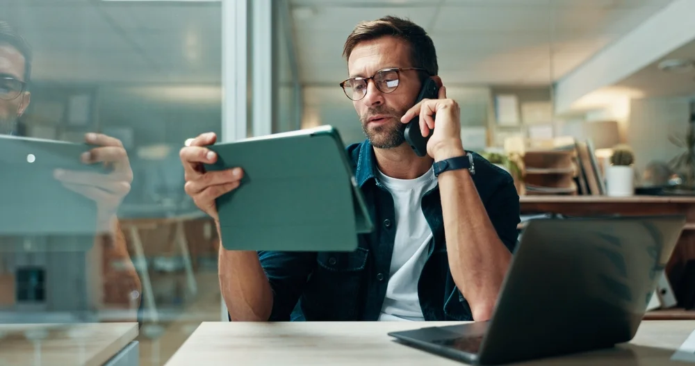 Journalist using a tablet, laptop, and smartphone for modern media kit