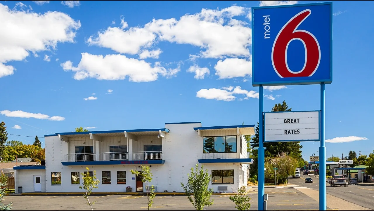 Motel 6 sign against a dark sky, illuminated, showcasing the brand identity