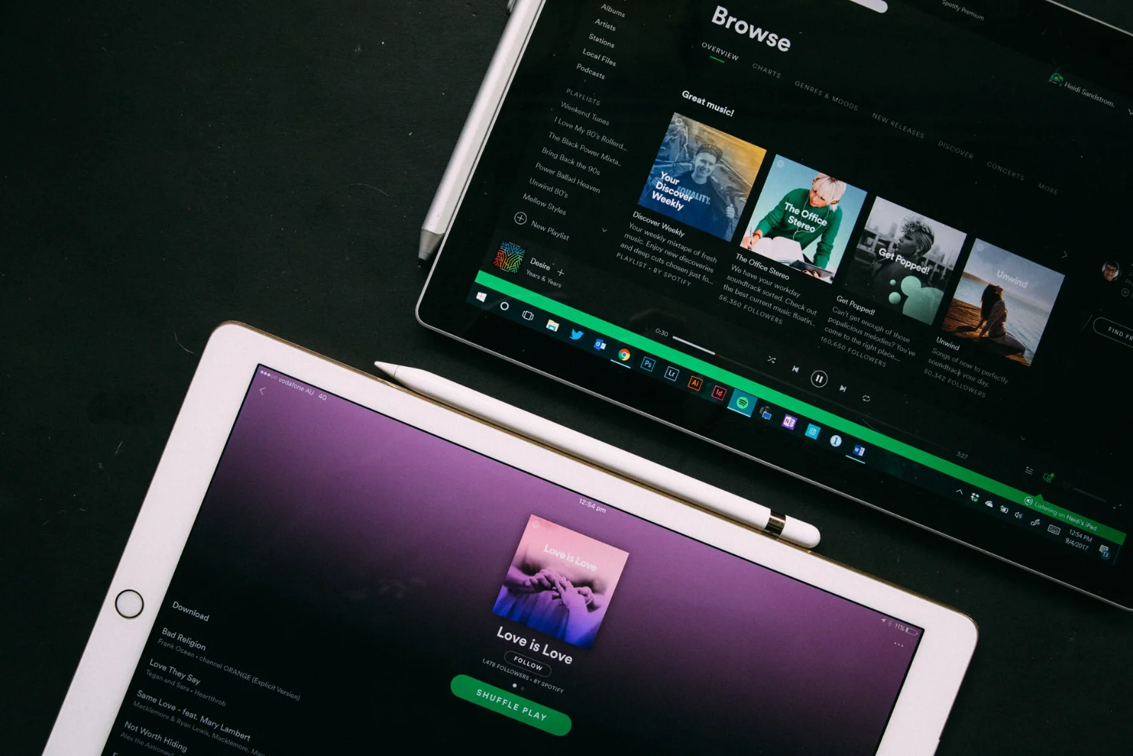 A person holding a phone with the Spotify app open, colorful background