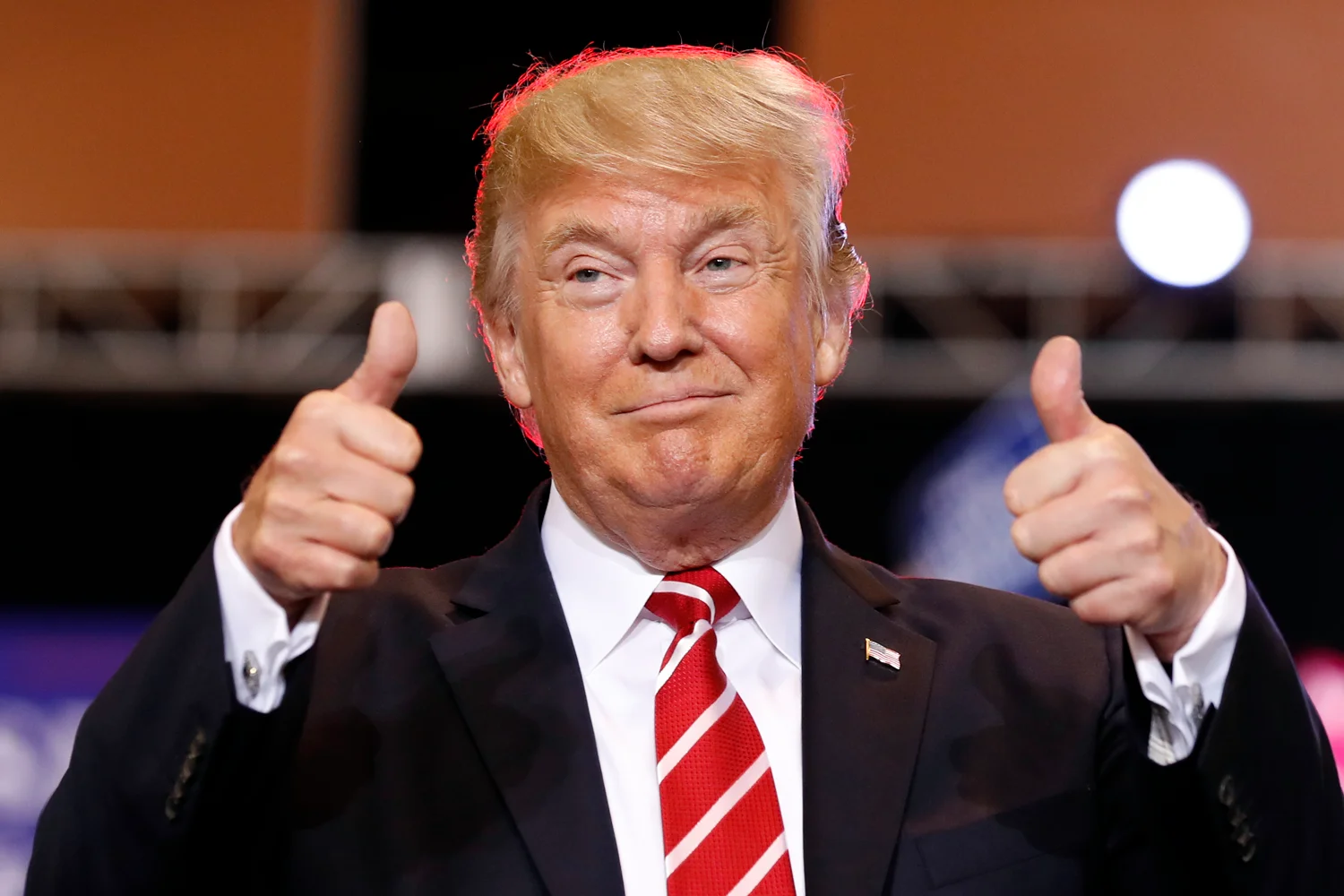 Donald Trump at his desk in the Oval Office, mid-speech