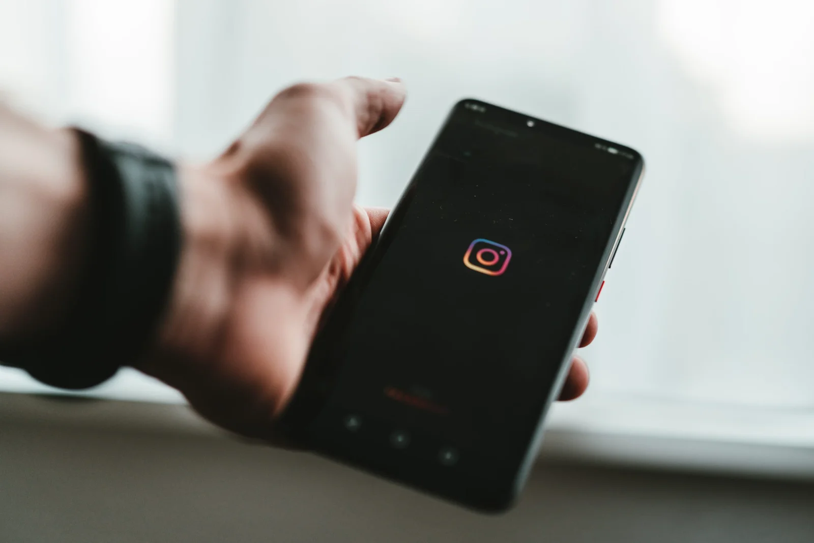 Flat lay image of a smartphone displaying Instagram logo surrounded by business-related items