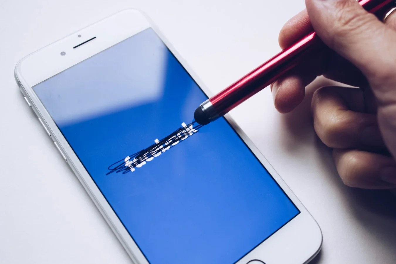 Facebook logos on a phone screen, symbolizing the departure of PR team members