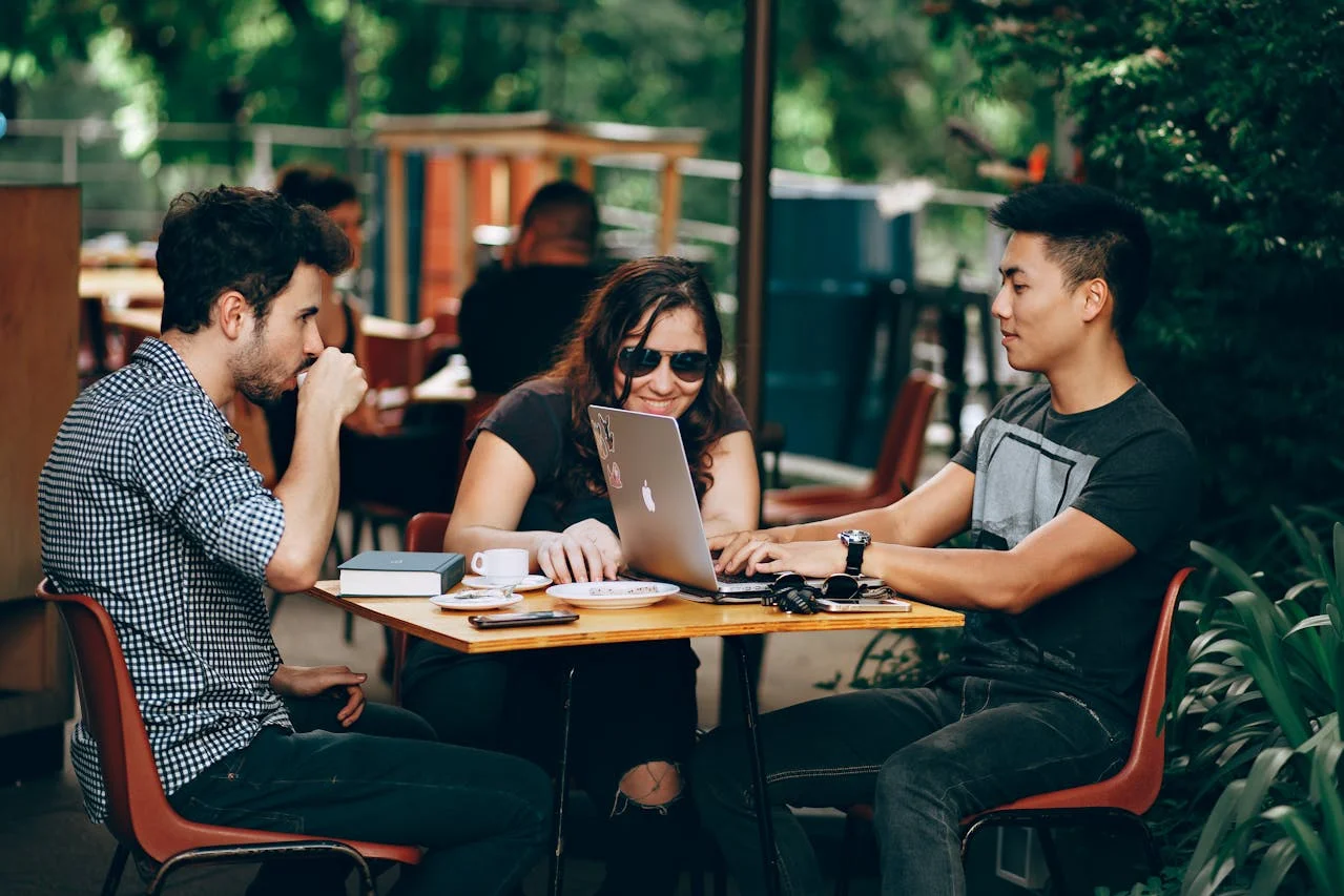 Agency team strategically planning a founder's media tour with laptops and notes