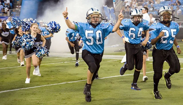 Young football players on the field, illustrating new scrutiny in youth sports