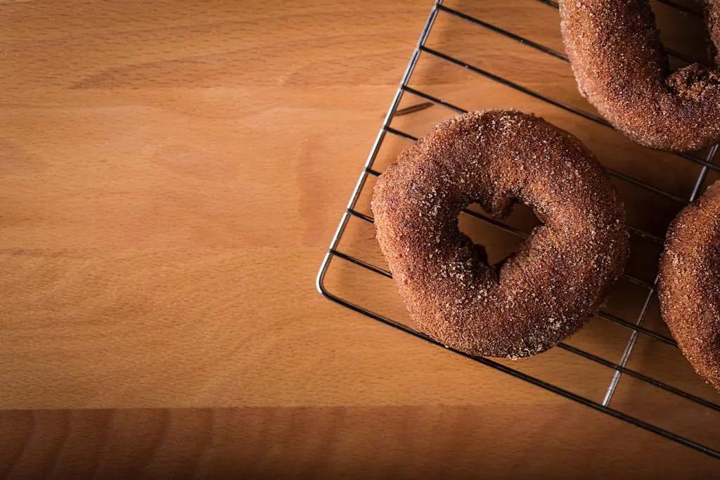 A plain doughnut cooling on a wire rack
