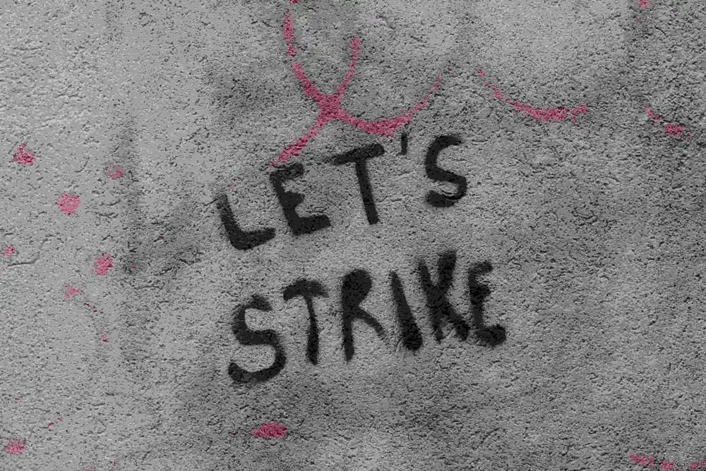 Actors on strike with picket signs, affecting new movie and TV show releases