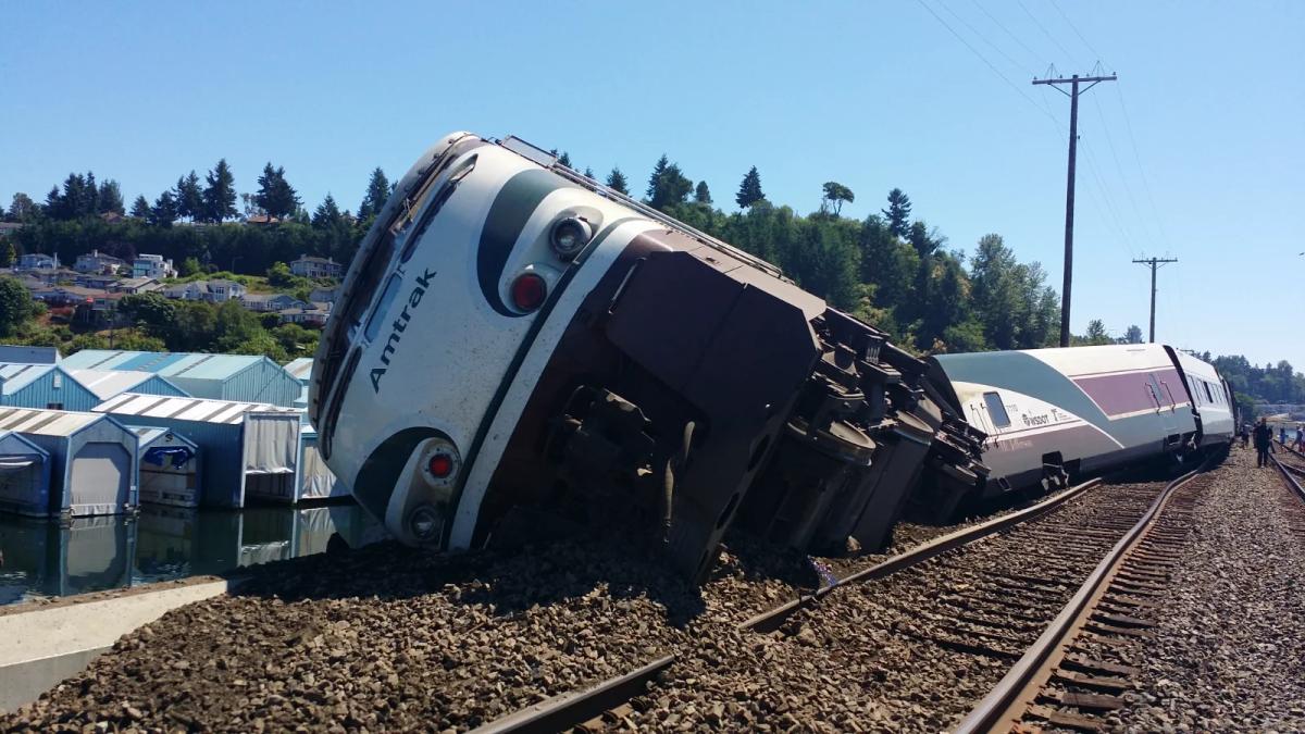 Cranes lift mangled rail cars after a train derailment accident investigation