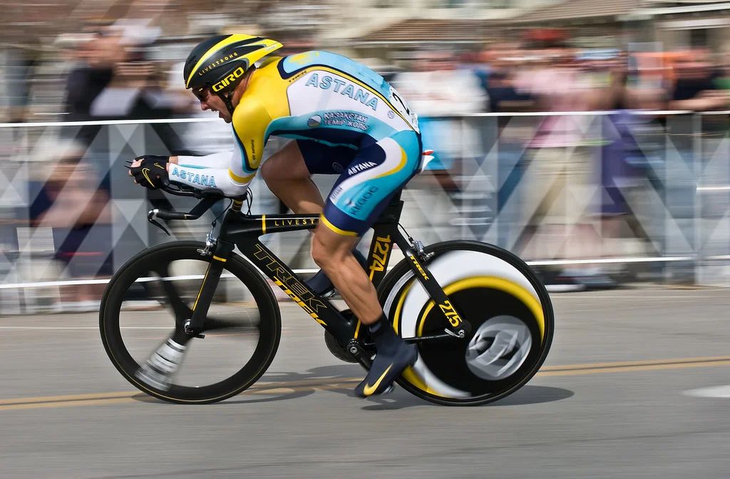 Lance Armstrong, a cyclist, holds his head in his hands, expressing shame