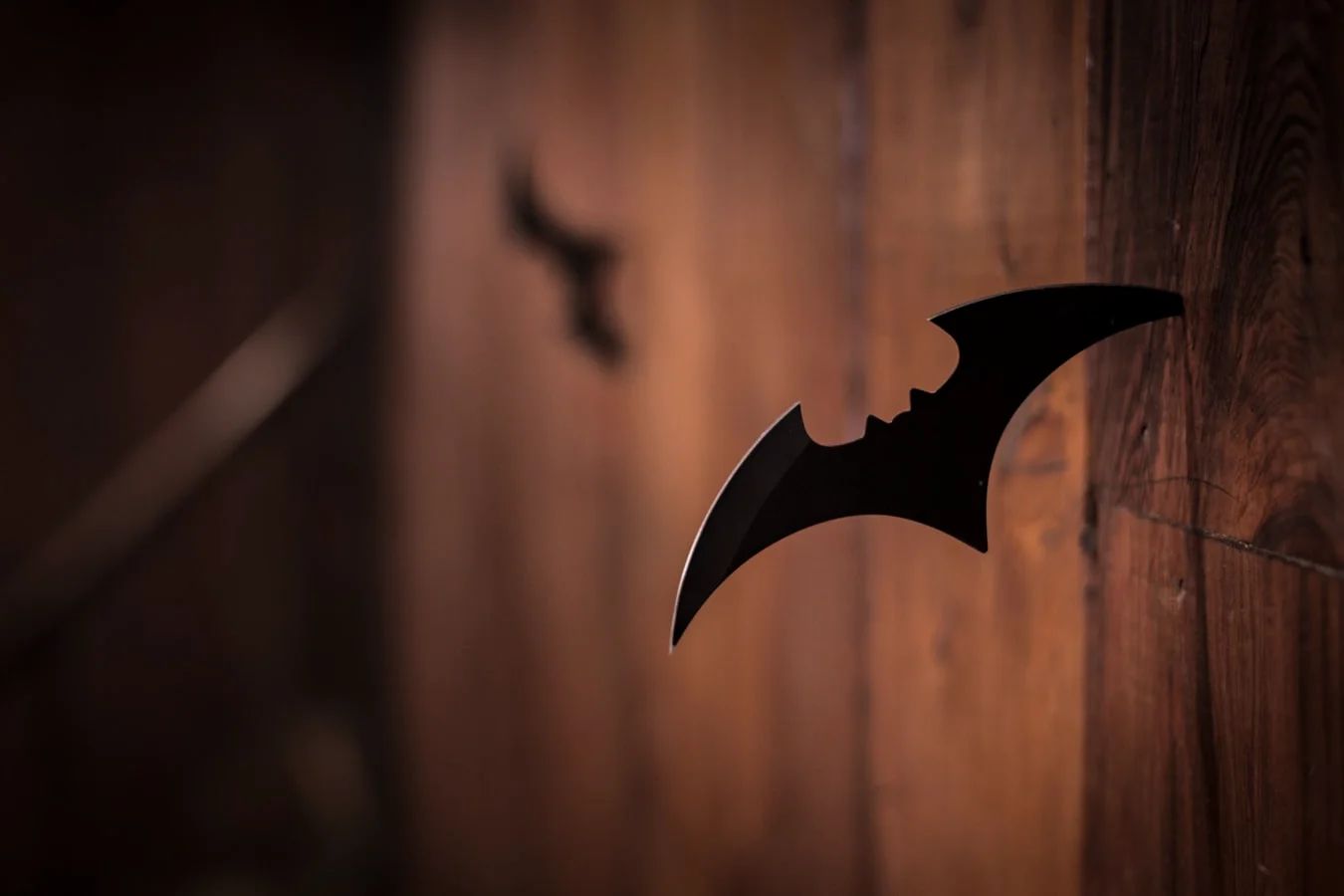A close-up of a brooding Batman in a dark, atmospheric shot