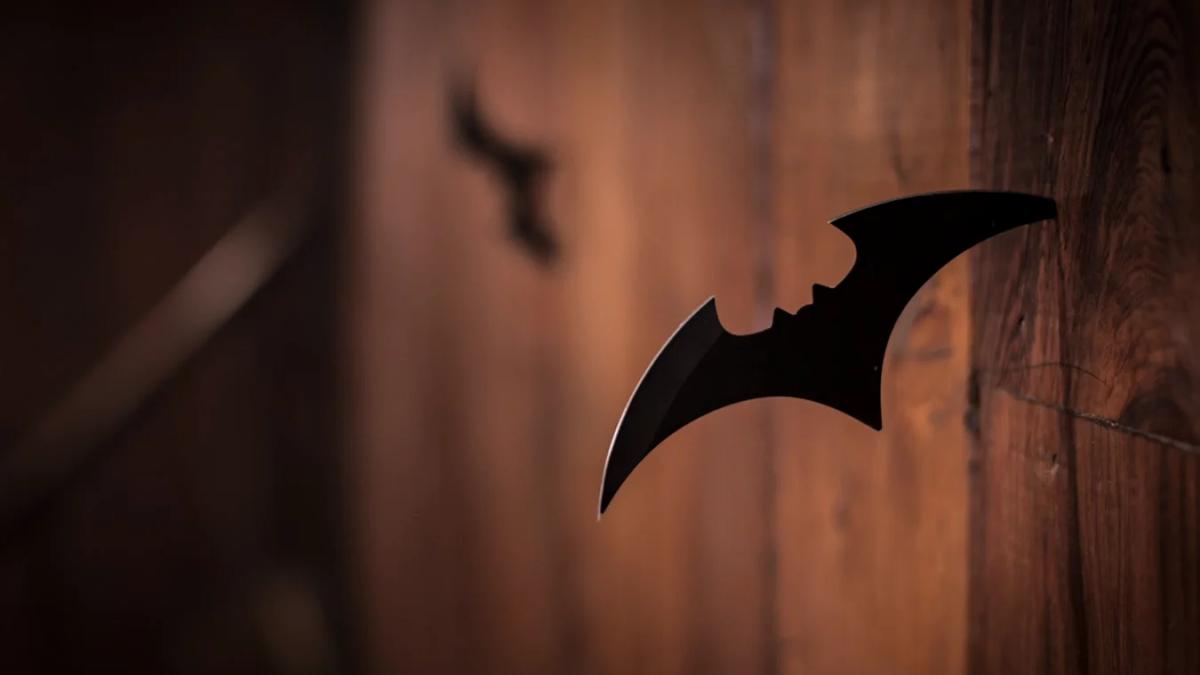 A close-up of a brooding Batman in a dark, atmospheric shot