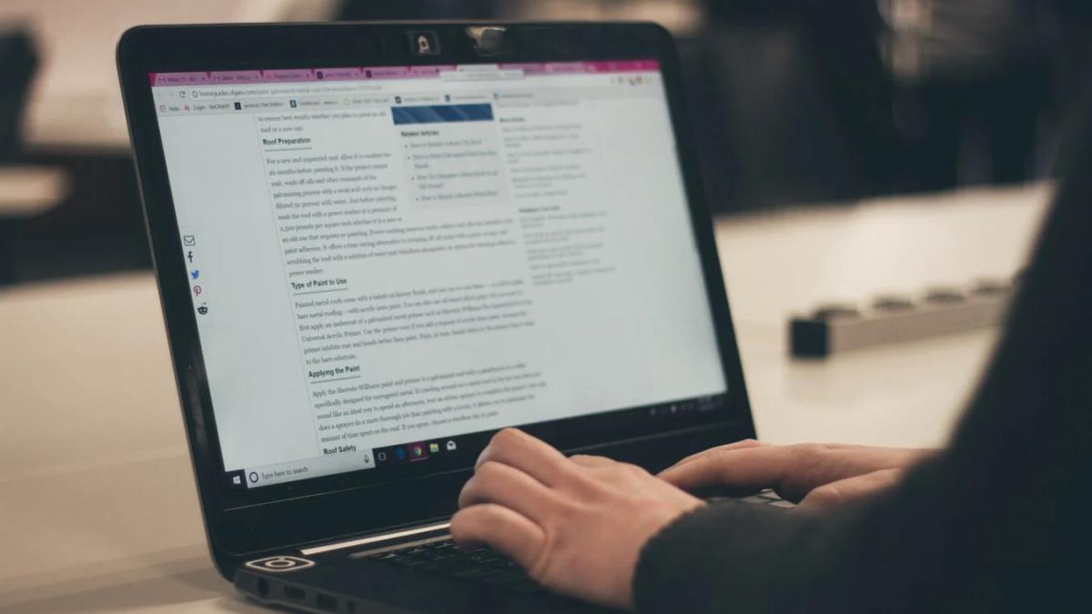 Blogger typing on keyboard with laptop, demonstrating a marketing strategy