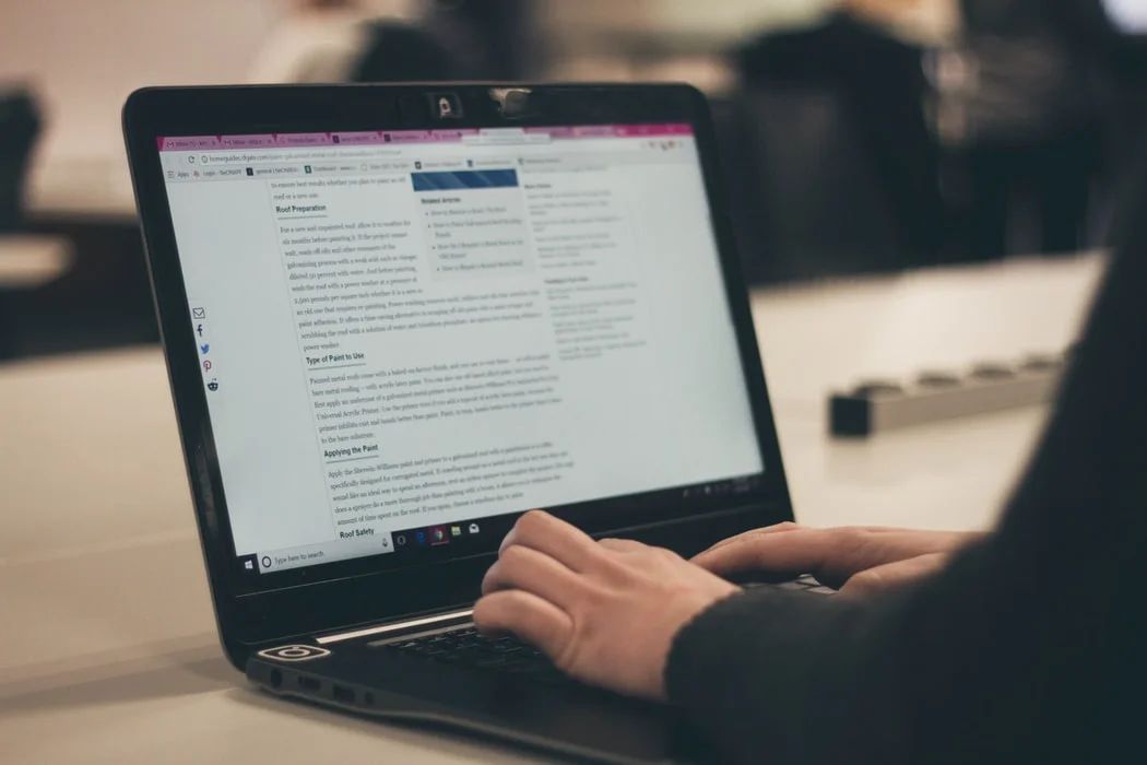 Young woman typing on laptop, showcasing the importance of blogging for content creation