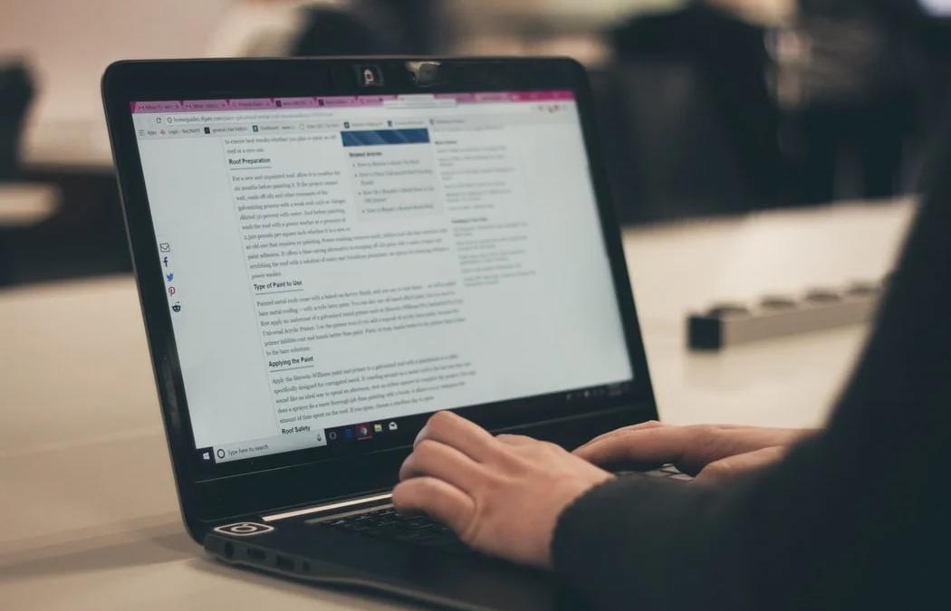 Young woman typing on laptop, showcasing the importance of blogging for content creation