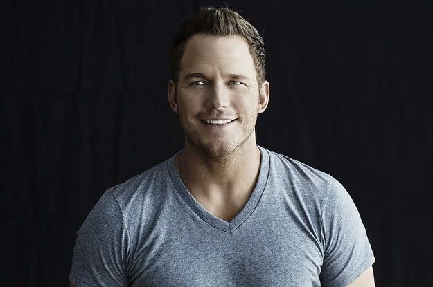 Chris Pratt smiling, posing with a bottle of Michelob Ultra beer