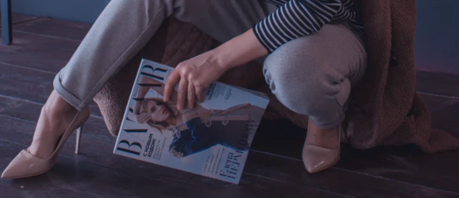 A person's hand holding a phone, scrolling through social media fashion posts