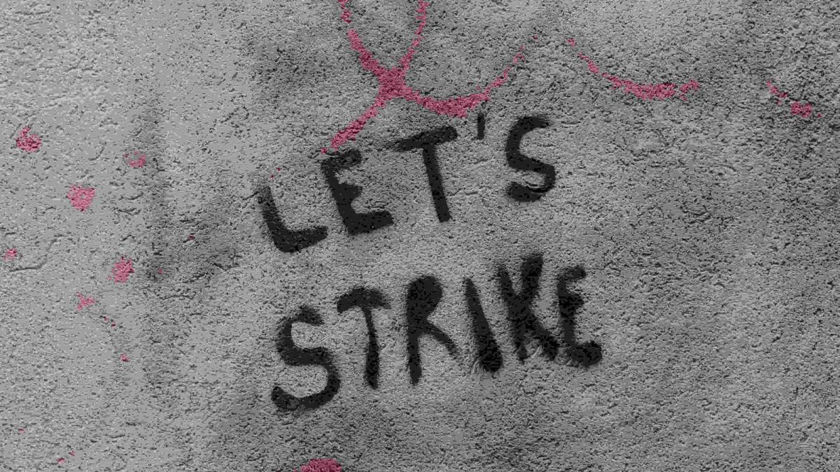 Actors on strike with picket signs, affecting new movie and TV show releases