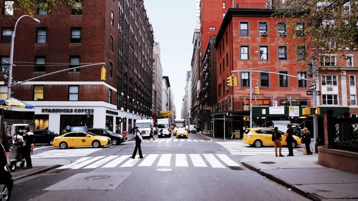 Pedestrians cautiously looking both ways before crossing a busy street for safety