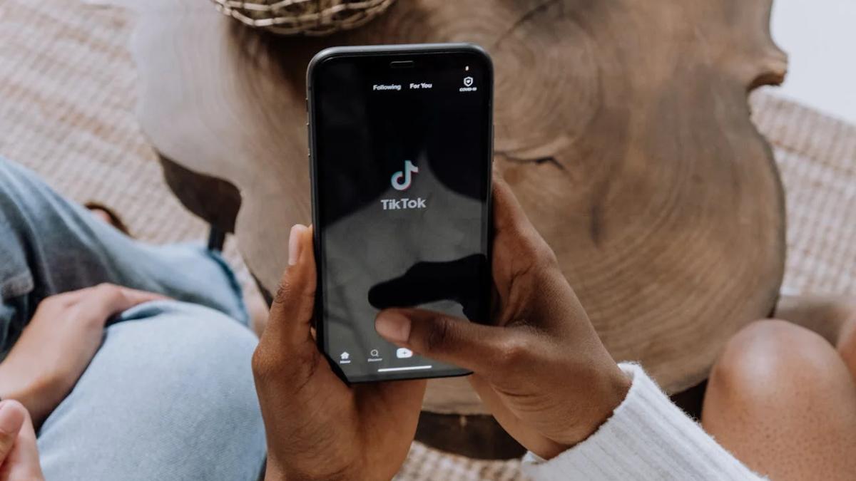 Man scrolling TikTok on phone, effective marketing to men strategy