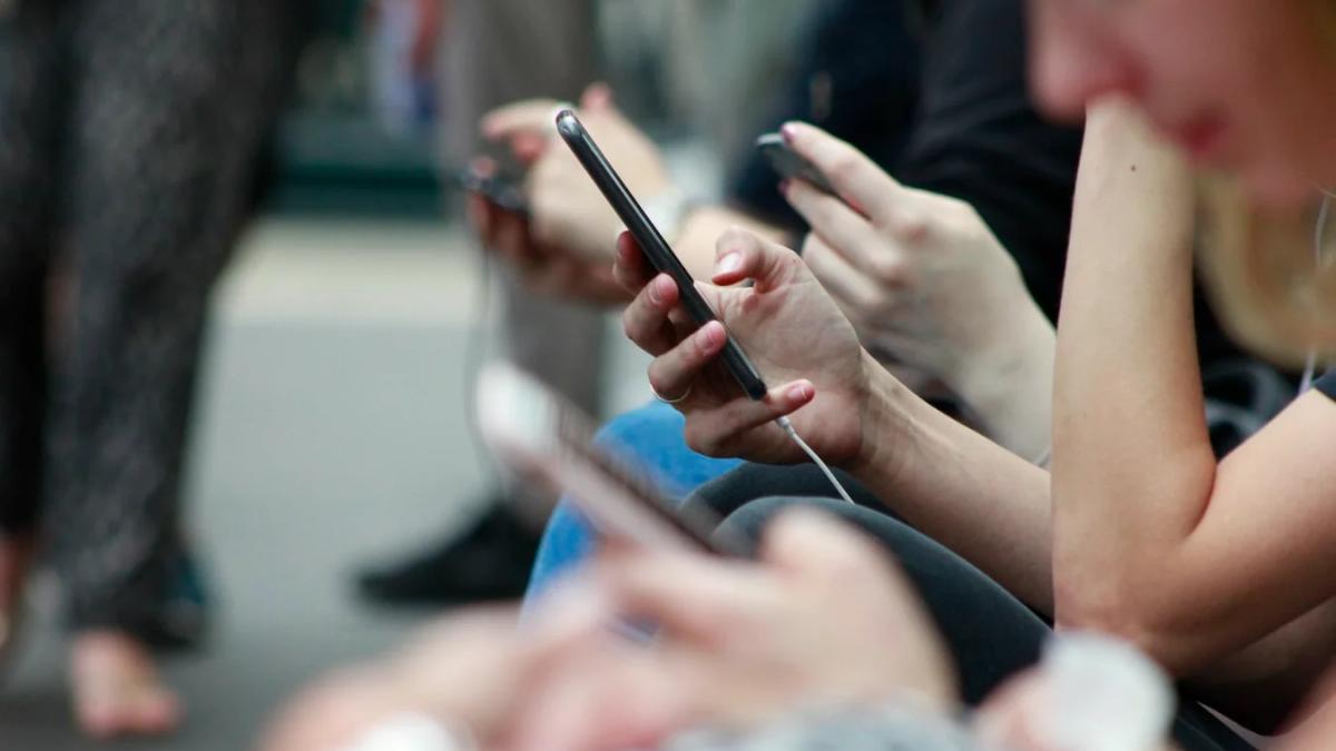 Hand holding a smartphone displaying marketing insights on screen, futuristic data concepts