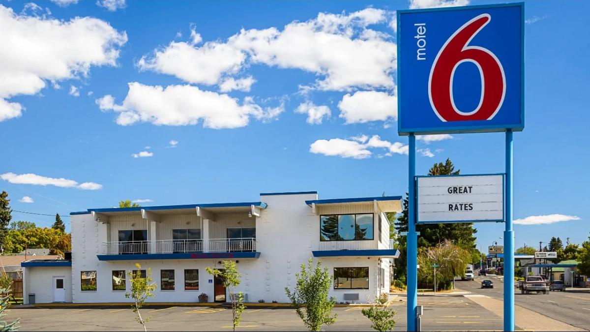 Motel 6 sign against a dark sky, illuminated, showcasing the brand identity