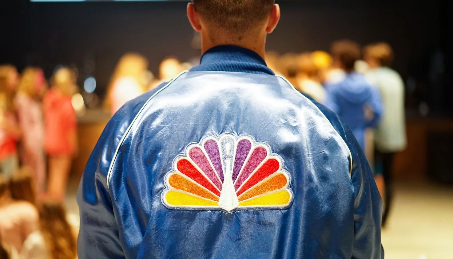 NBC streaming service logo against a backdrop of film reels, symbolizing content creation