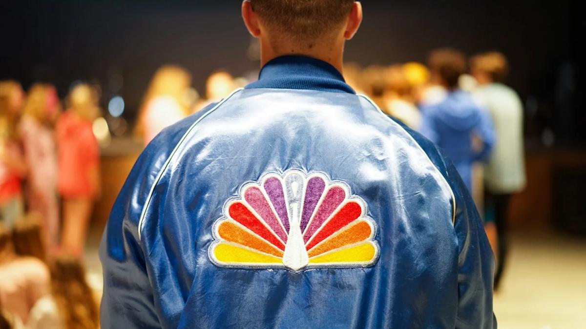 NBC streaming service logo against a backdrop of film reels, symbolizing content creation