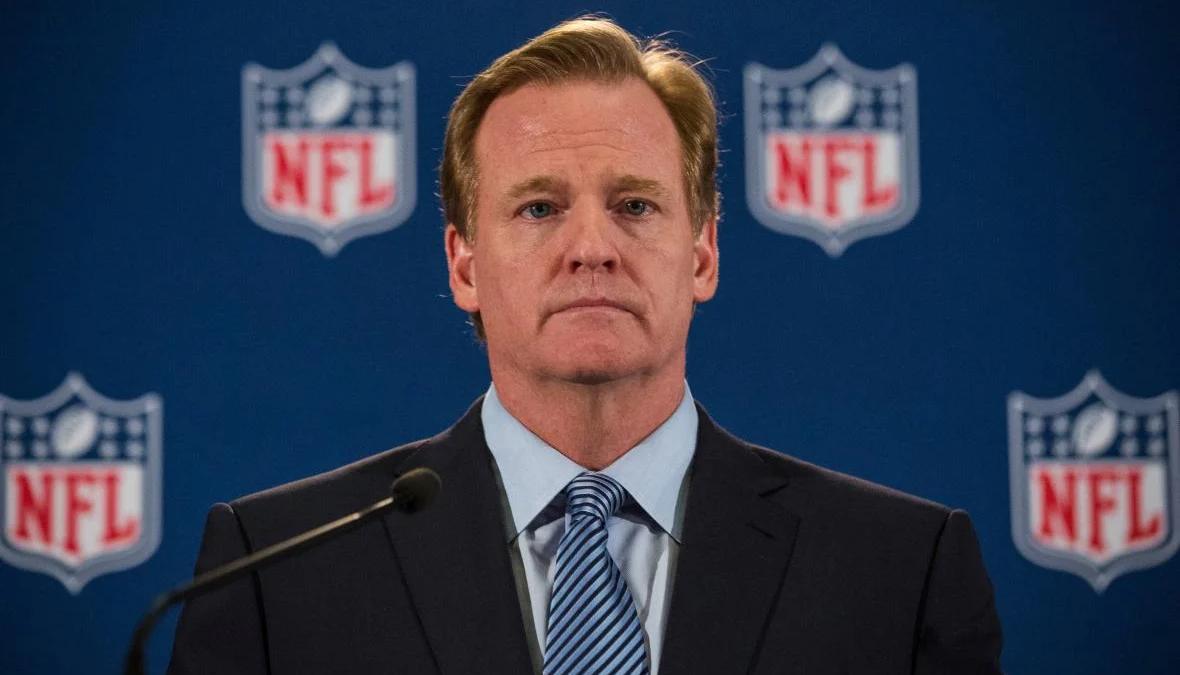 Jerry Jones staring intently at Roger Goodell, NFL commissioners meeting in conflict