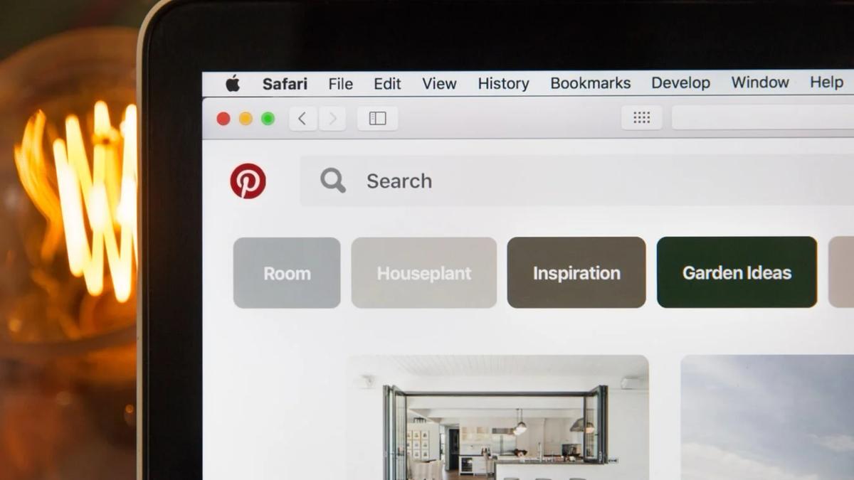 Young woman pinning an image on a laptop, optimizing for Pinterest marketing