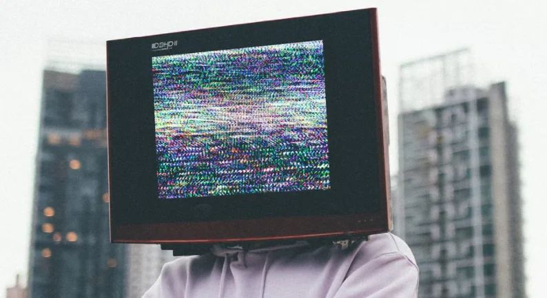 Close-up of a person's hand typing on a laptop with product content on screen