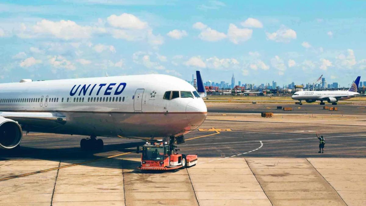 United Airlines crew smiling while serving passengers on a modern airplane