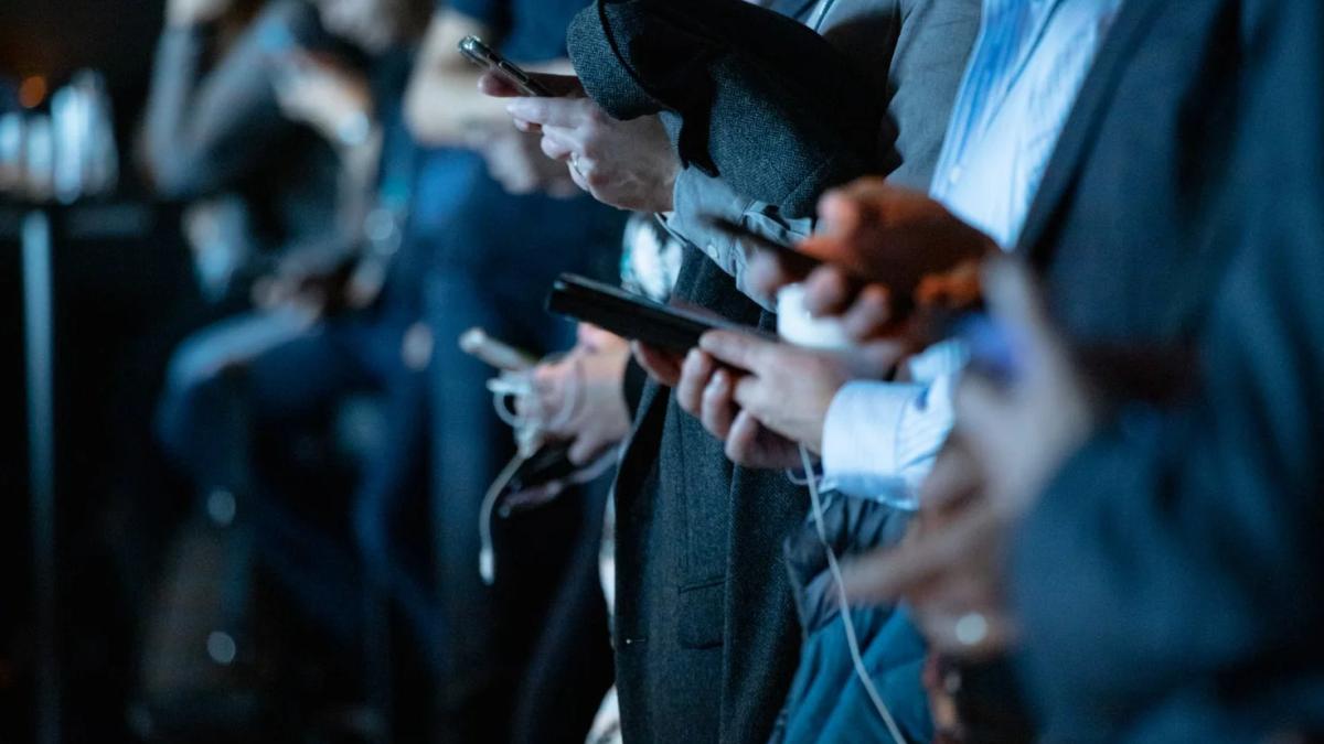 Person uses a magnifying glass to examine a news article for trustworthiness