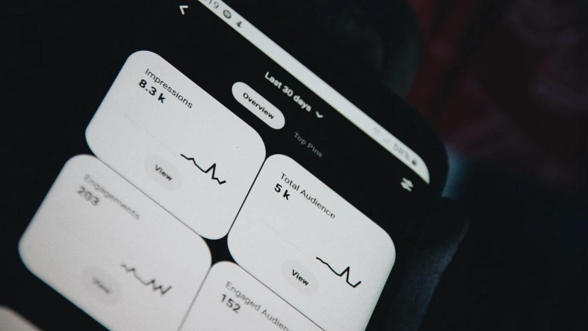 Hands holding a phone, navigating Pinterest to strategize marketing success