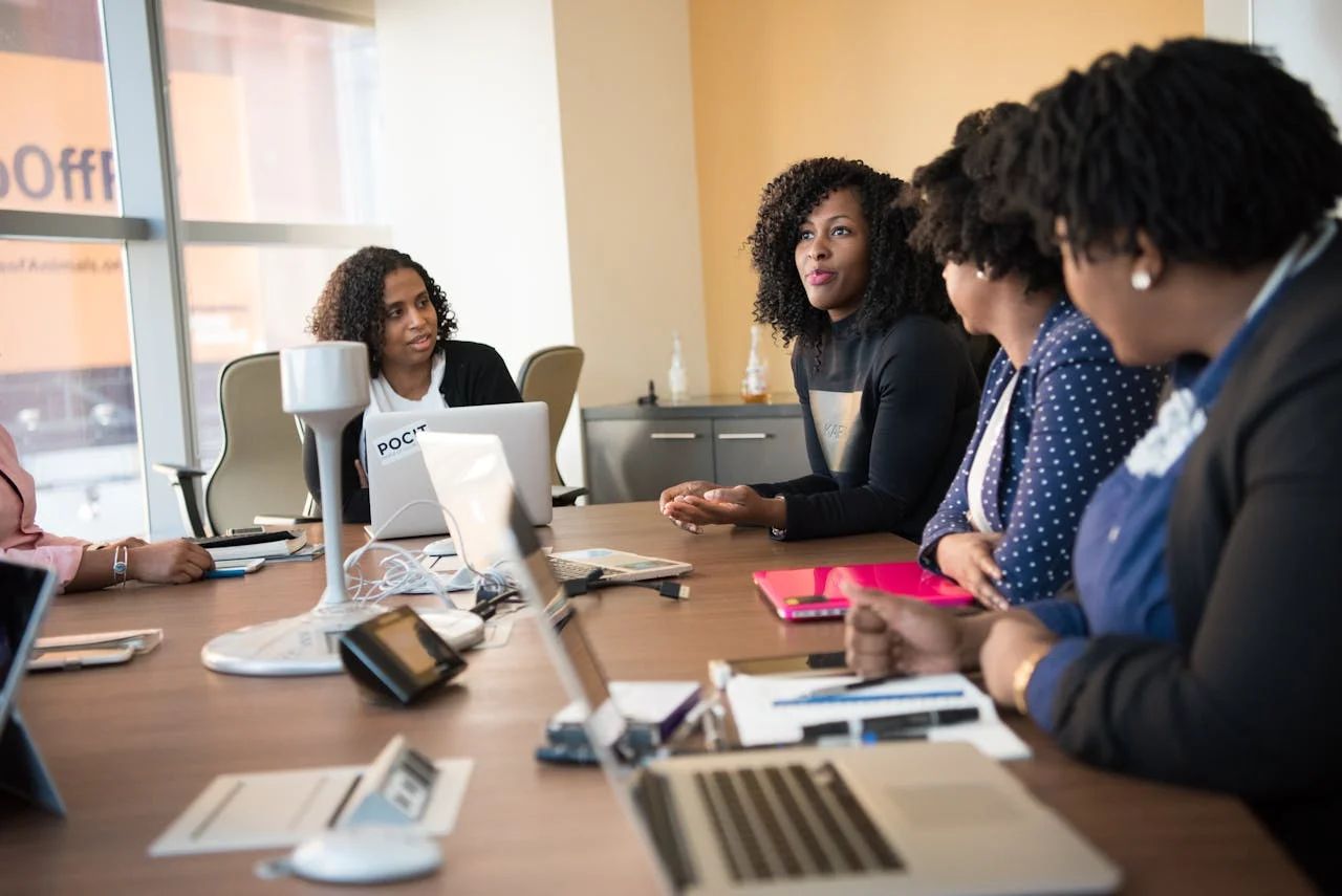 People on laptops in a bright, modern office, engaged in open communication