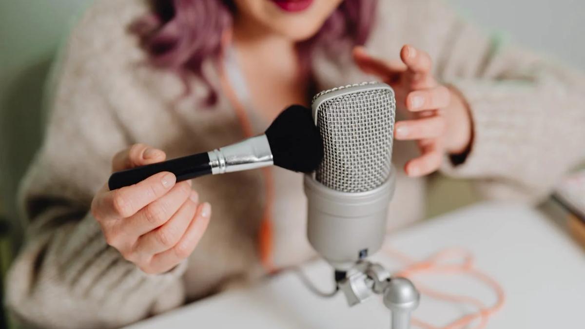 Woman whispering into a microphone, headphones on, demonstrating ASMR marketing techniques