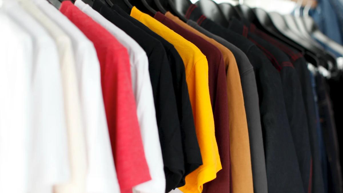 Shoppers browse racks of stylish used clothing in a trendy, sustainable boutique
